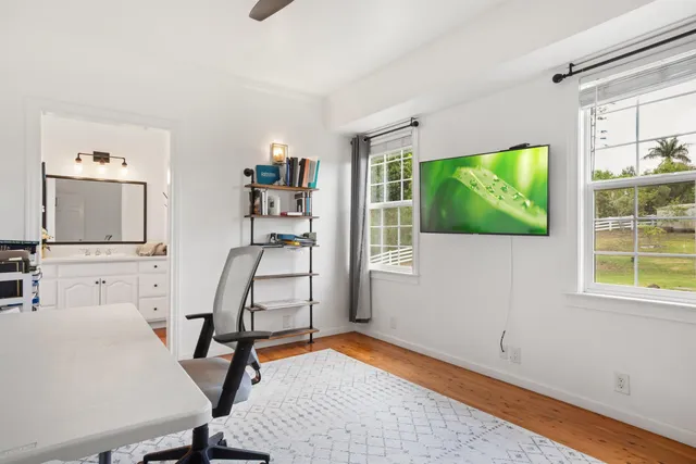 a view of a workspace with furniture and a window