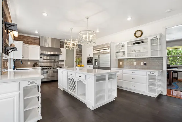 a kitchen with white cabinets and stainless steel appliances