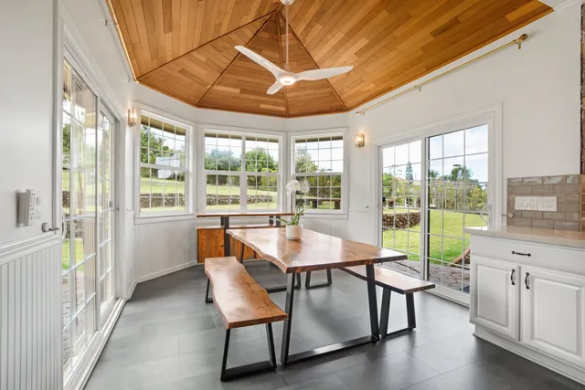 a dining room with furniture a chandelier and wooden floor