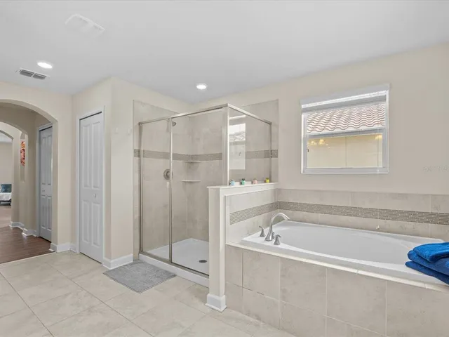 a spacious bedroom with a bed and a chandelier