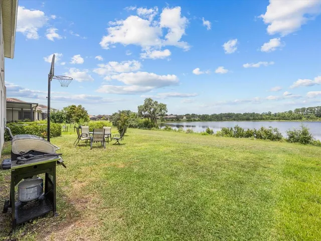 a view of a lake with table and chairs