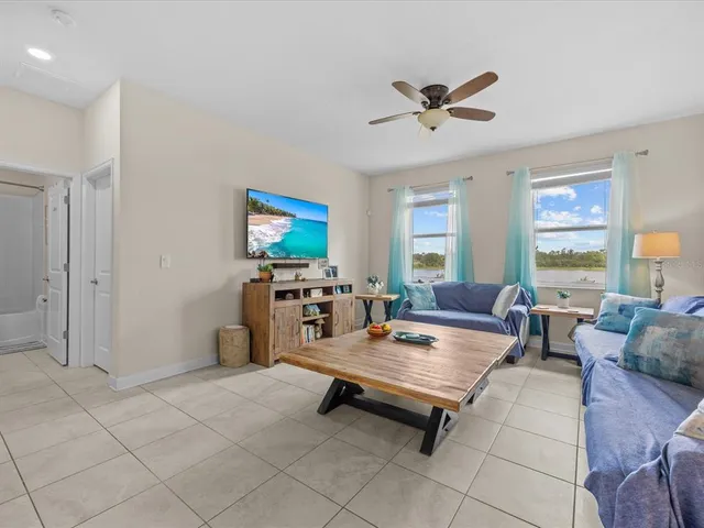 a living room with furniture a ceiling fan and a window