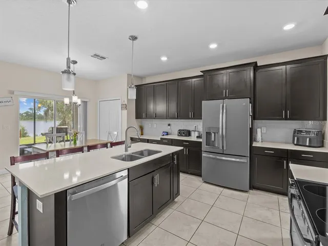 a kitchen with granite countertop a sink stainless steel appliances and cabinets