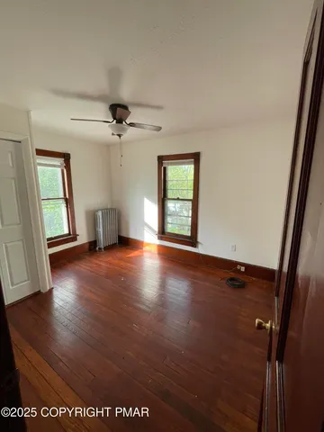 wooden floor in an empty room with a window