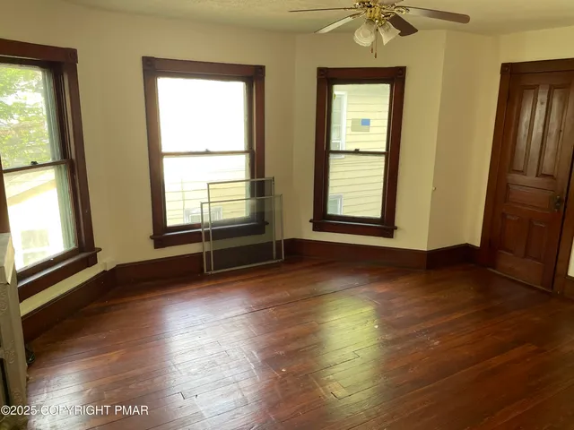 a view of a livingroom with wooden floor and a window