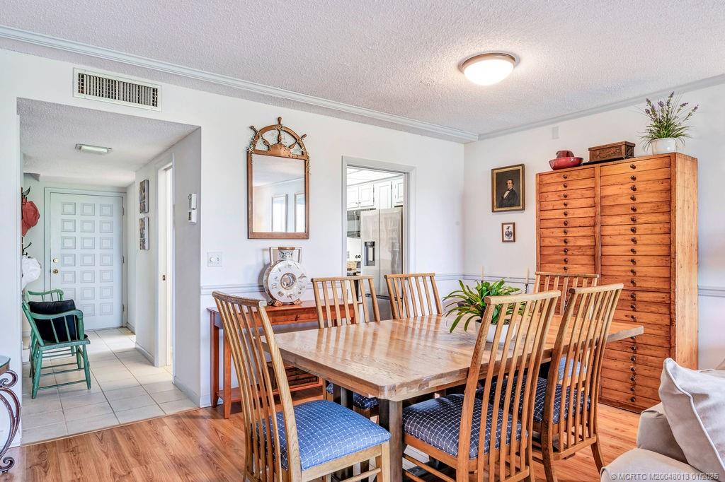 3901 Southeast St Lucie Boulevard, Unit 75 Stuart, FL 34997 - Photo 30 of 48 a view of a dining room with furniture and wooden floor