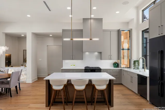 a kitchen with stainless steel appliances kitchen island granite countertop a kitchen island a hardwood floor and a sink