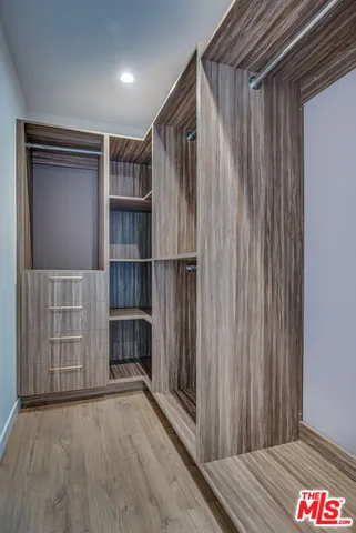 a view of an empty room with wooden shelves