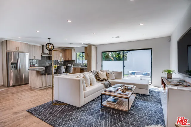 a living room with furniture and a view of kitchen