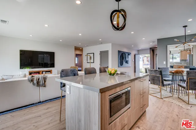 a kitchen with stainless steel appliances granite countertop a stove top oven a sink dishwasher and white countertops with wooden floor