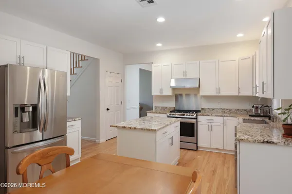 a kitchen with stainless steel appliances granite countertop a stove a refrigerator and a refrigerator