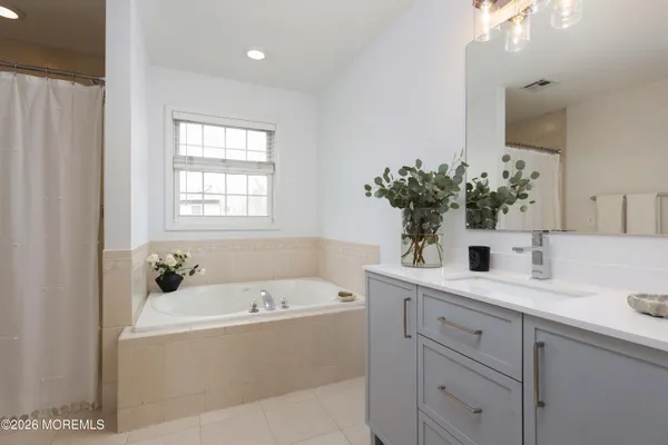 a white bath tub sitting next to a bathroom sink
