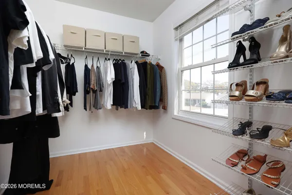 a view of walk in closet with clothes and shoes