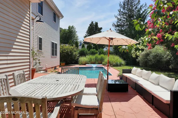a view of a patio with couches table and chairs under an umbrella