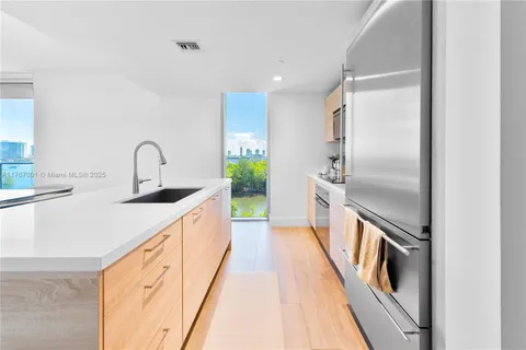 a kitchen with kitchen island granite countertop a sink and refrigerator