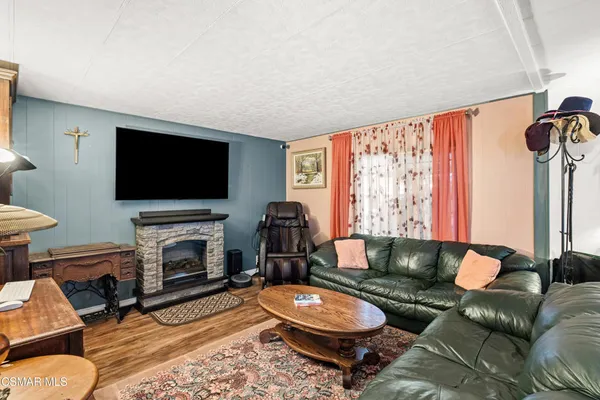 a living room with furniture a flat screen tv and a fireplace