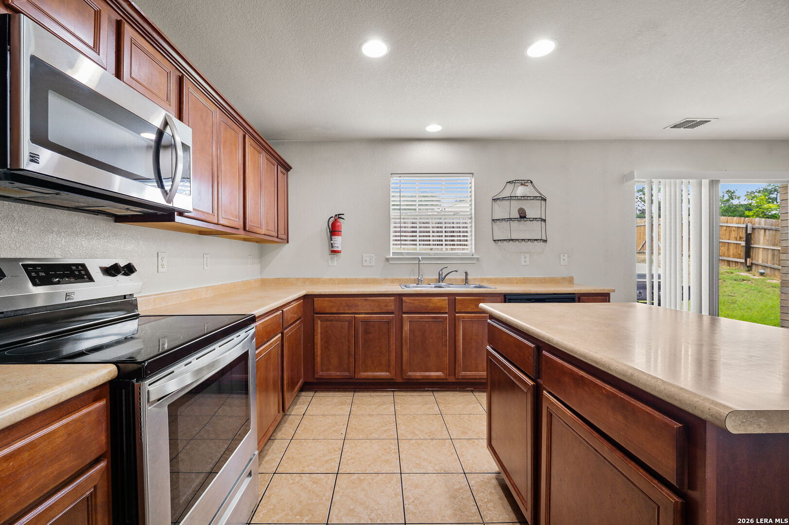 7207 Avery Road Live Oak, TX 78233 - Photo 18 of 32 a kitchen with stainless steel appliances granite countertop a sink and cabinets