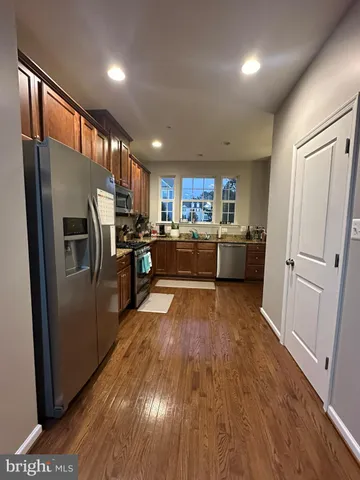 a kitchen with refrigerator a microwave and wooden floor