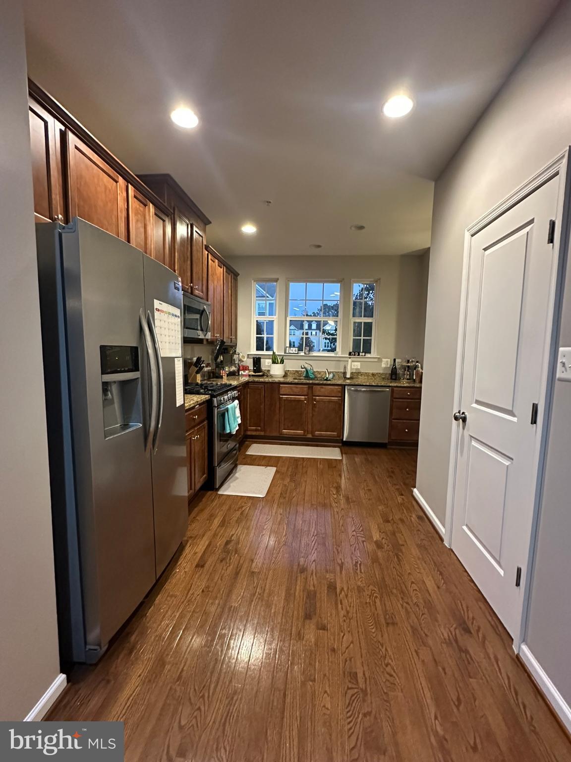 23171 Ambrosia Lane California, MD 20619 - Photo 6 of 18 a kitchen with refrigerator a microwave and wooden floor