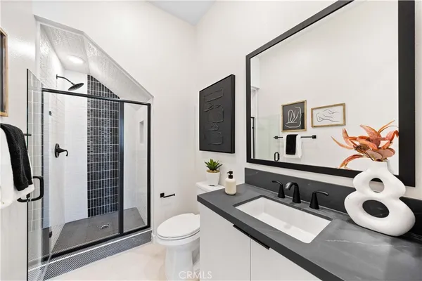 a bathroom with a granite countertop sink mirror vanity and toilet