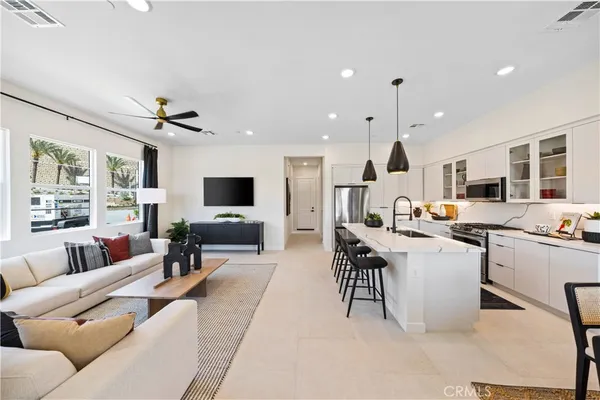 a living room with furniture kitchen view and a flat screen tv