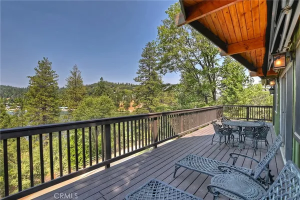 a balcony with wooden floor and outdoor seating
