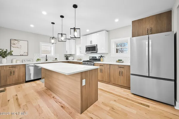 a kitchen with stainless steel appliances granite countertop a sink stove a refrigerator and a oven with wooden floor