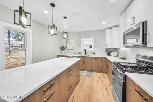 a large kitchen with stainless steel appliances kitchen island granite countertop a sink and cabinets