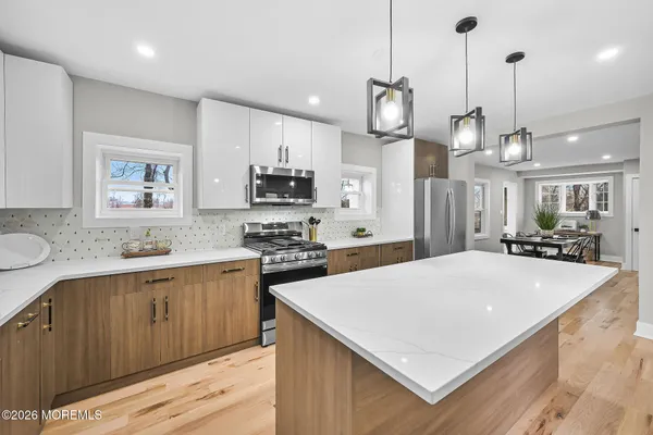a large kitchen with stainless steel appliances a stove a sink a center island a refrigerator and a stove