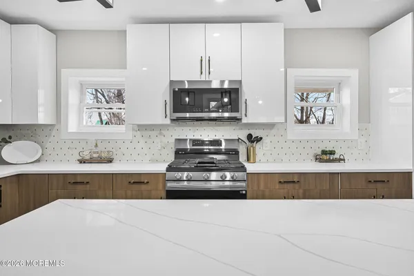 a kitchen with stainless steel appliances a stove and white cabinets