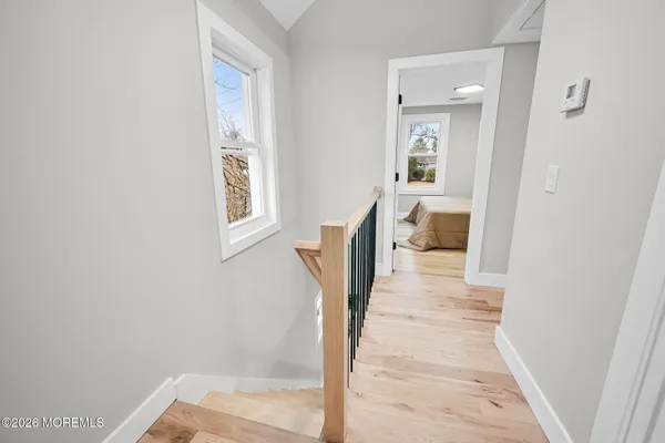 a view of a hallway with wooden floor and a living room