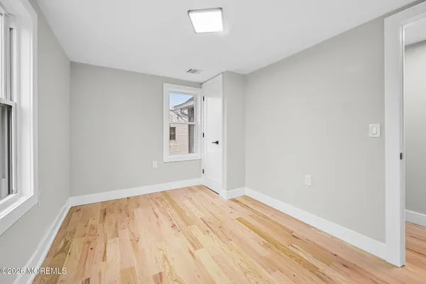 a view of empty room with wooden floor