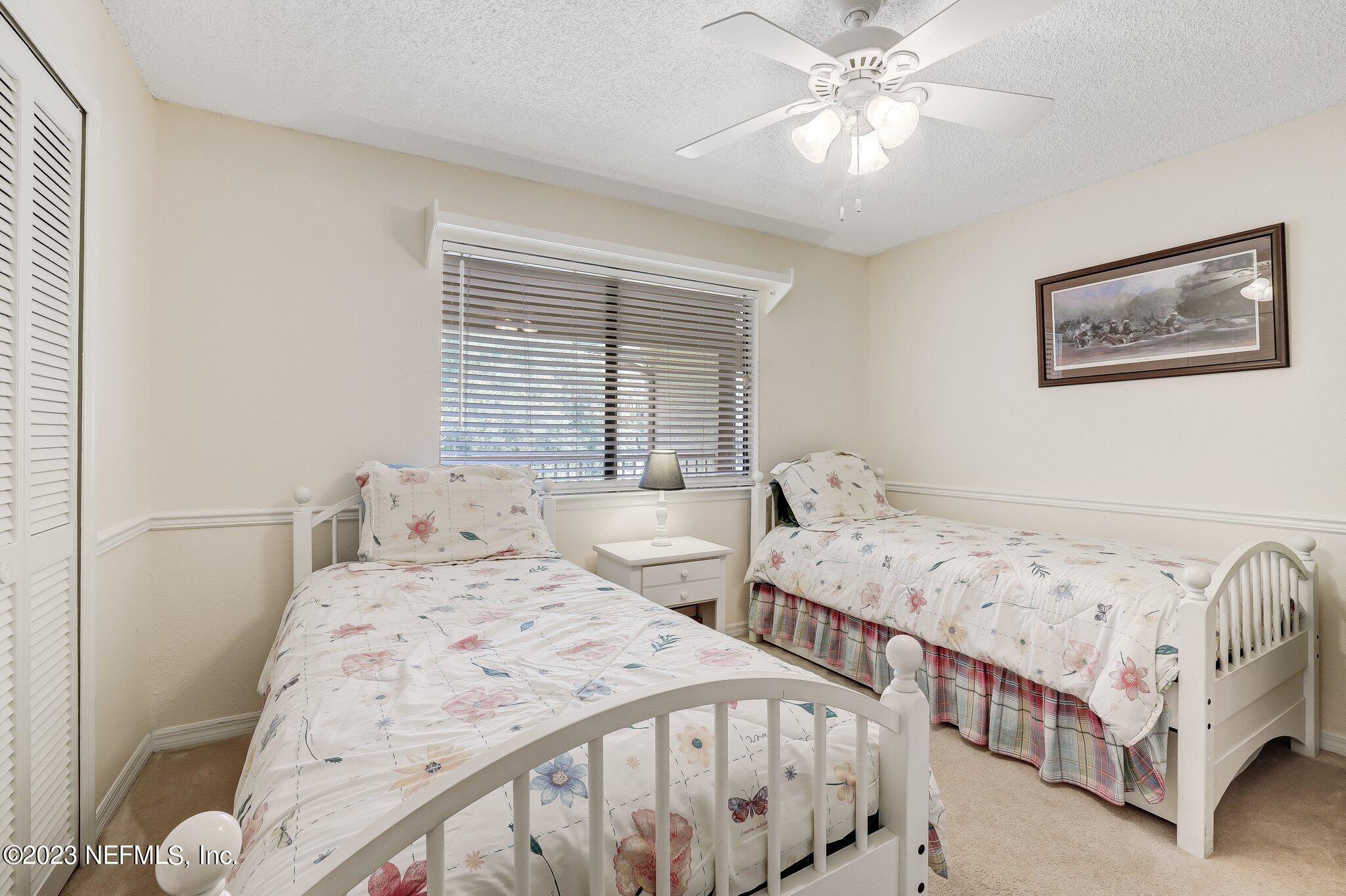 99 Broad River Place, Unit 1301 Welaka, FL 32193 - Photo 23 of 50 a bedroom with two beds and a chandelier