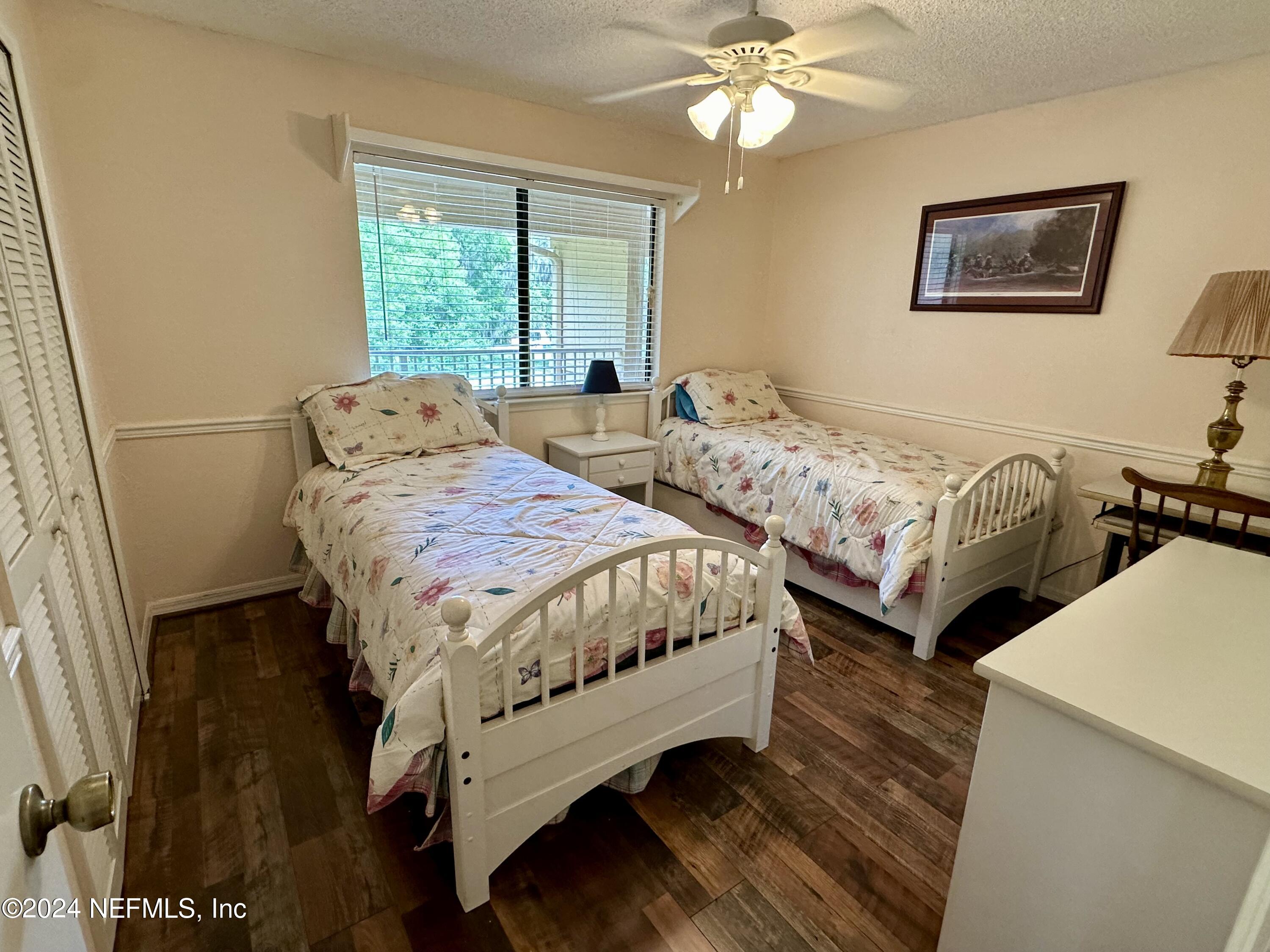 99 Broad River Place, Unit 1301 Welaka, FL 32193 - Photo 24 of 50 a bedroom with two beds and a chandelier