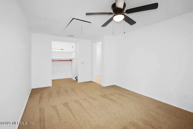 a view of empty room with ceiling fan