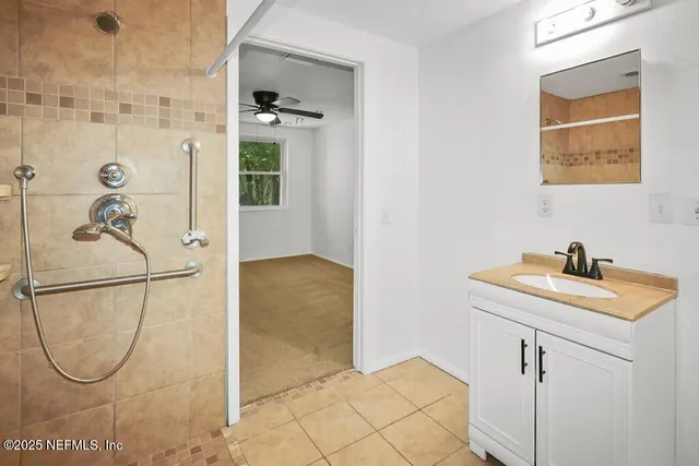 a bathroom with a granite countertop shower a sink and vanity