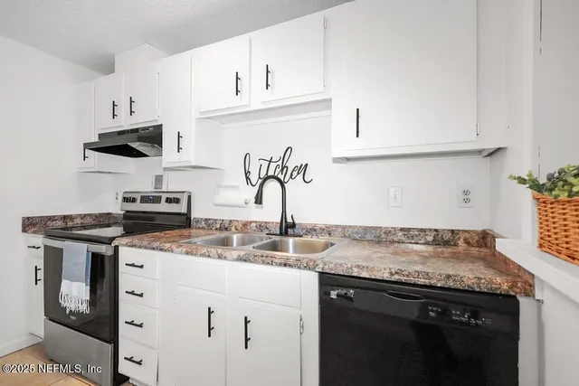 a kitchen with cabinets appliances a sink and a counter top