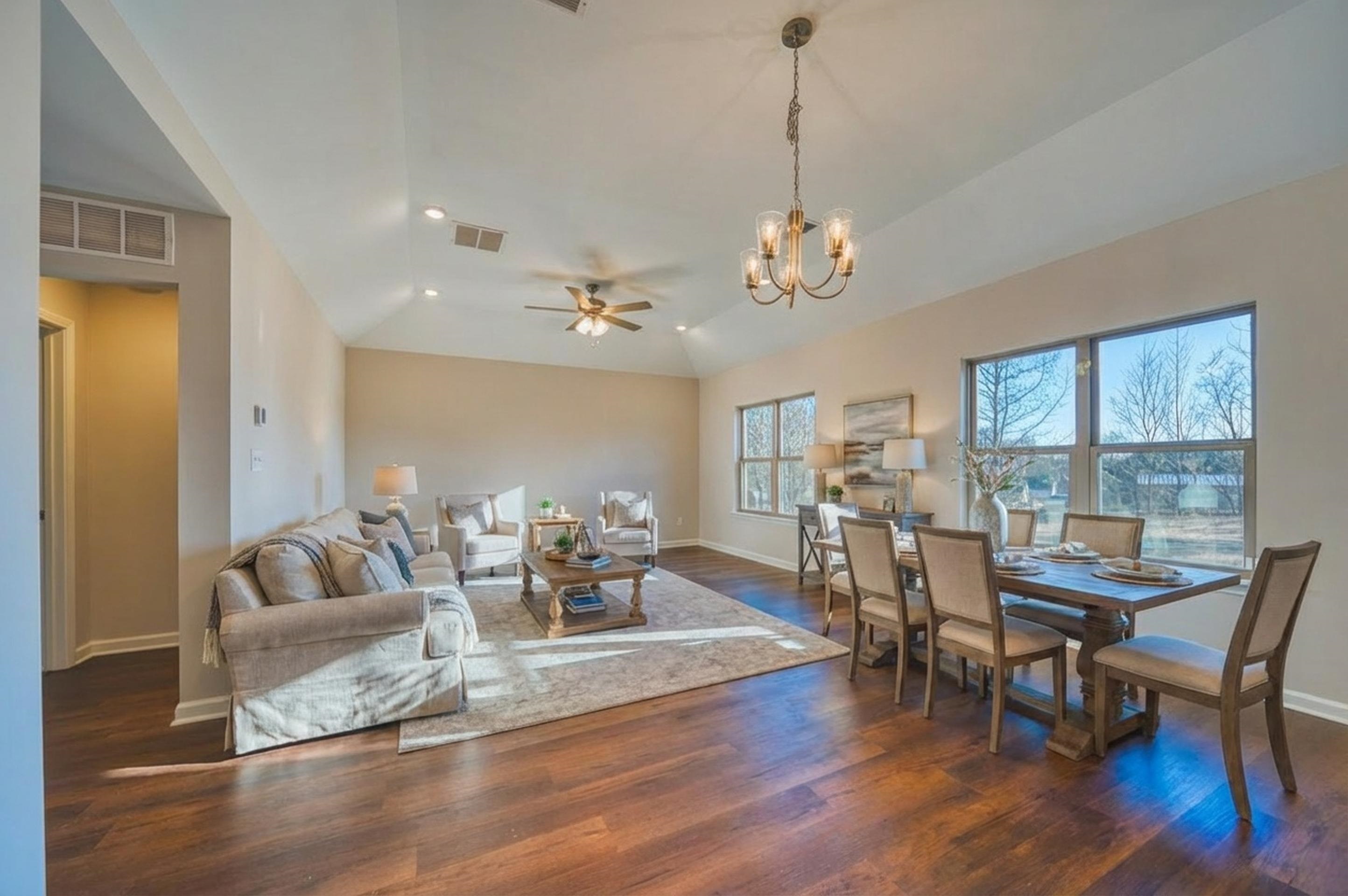 Living area featuring dark wood-style floors, a ceiling fan, a chandelier, vaulted ceiling, and recessed lighting