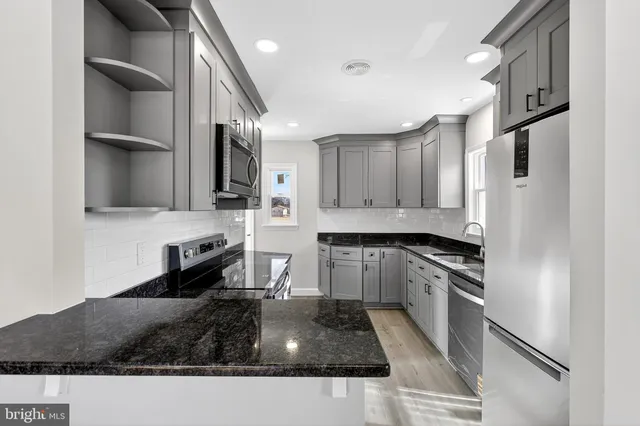 a kitchen with granite countertop stainless steel appliances and wooden cabinets