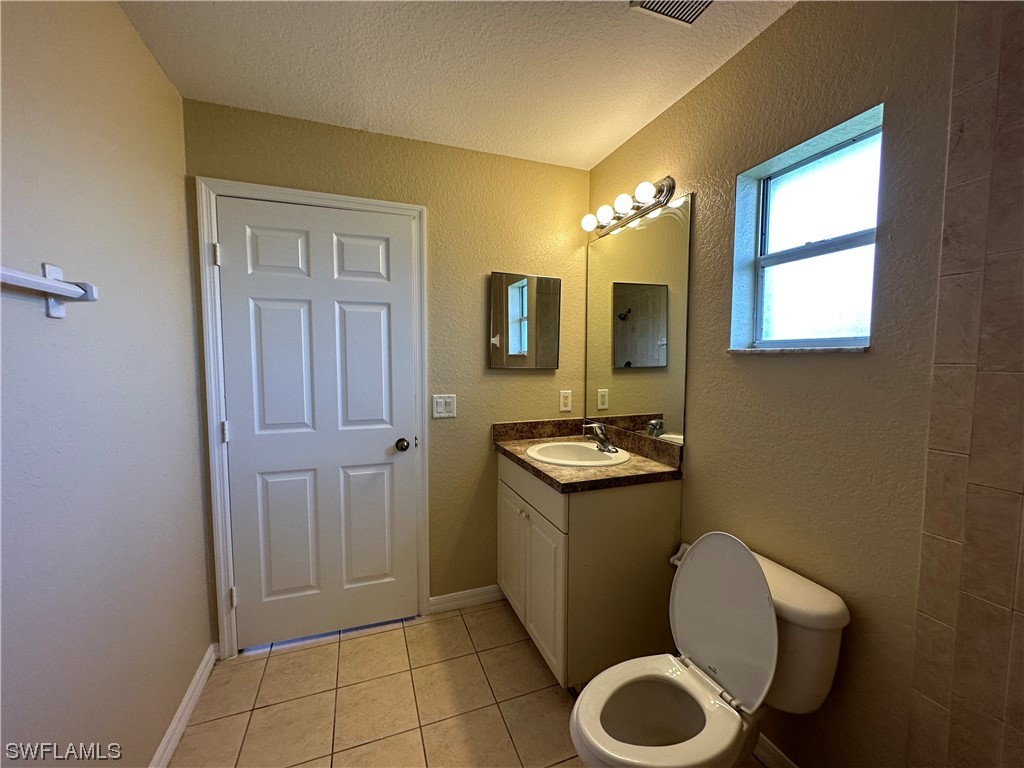 4106 24th Street Southwest Lehigh Acres, FL 33976 - Photo 14 of 15 a bathroom with a toilet sink and mirror