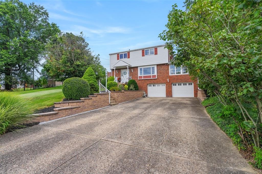 4 Cheryl Drive Coraopolis, PA 15108 - Photo 2 of 32 a front view of a house with a yard and a garage