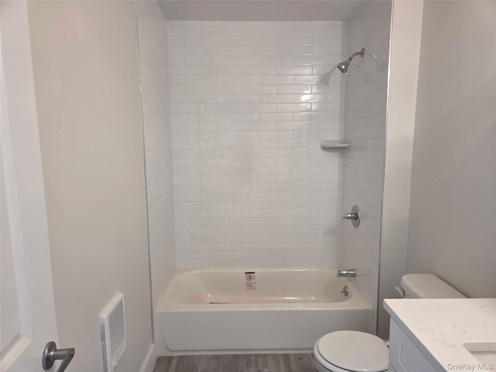 539 Front Street, Unit 4C Hempstead, NY 11550 - Photo 11 of 17 Bathroom featuring shower / tub combination, vanity, and wood finished floors