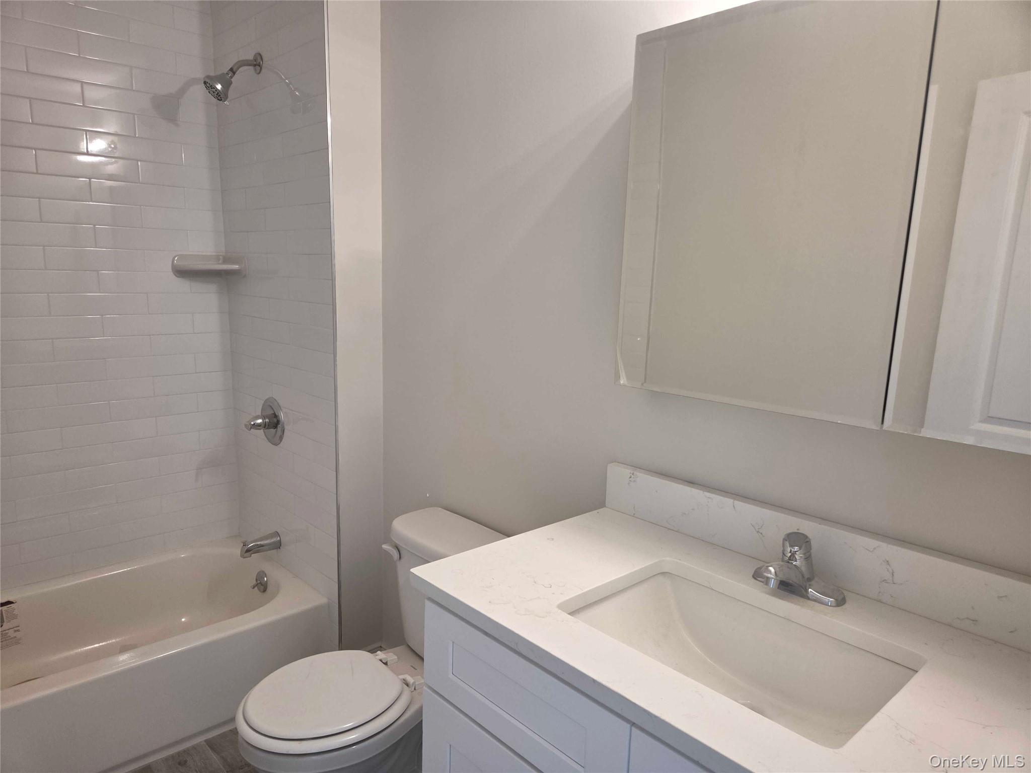 539 Front Street, Unit 4C Hempstead, NY 11550 - Photo 10 of 17 Full bathroom with washtub / shower combination and vanity