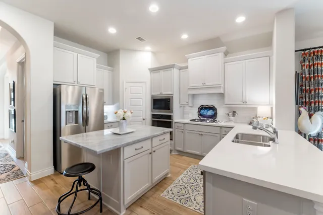 a kitchen with a refrigerator a sink and cabinets