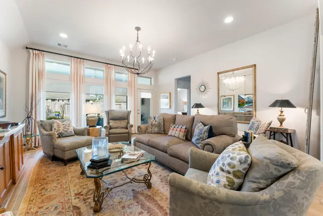 a living room with furniture chandelier and a large window