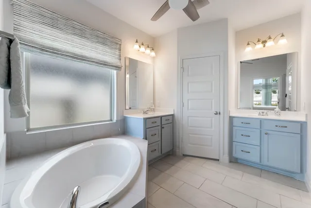 a bathroom with a tub sink and mirror