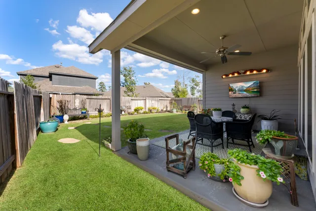 a view of a patio with chairs potted plants with large tree