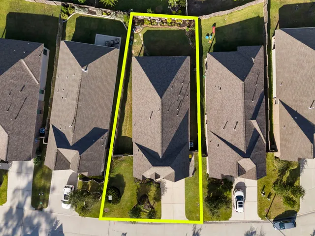 an aerial view of residential houses with outdoor space and swimming pool