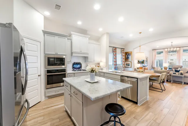 a kitchen with stainless steel appliances granite countertop a stove refrigerator and cabinets