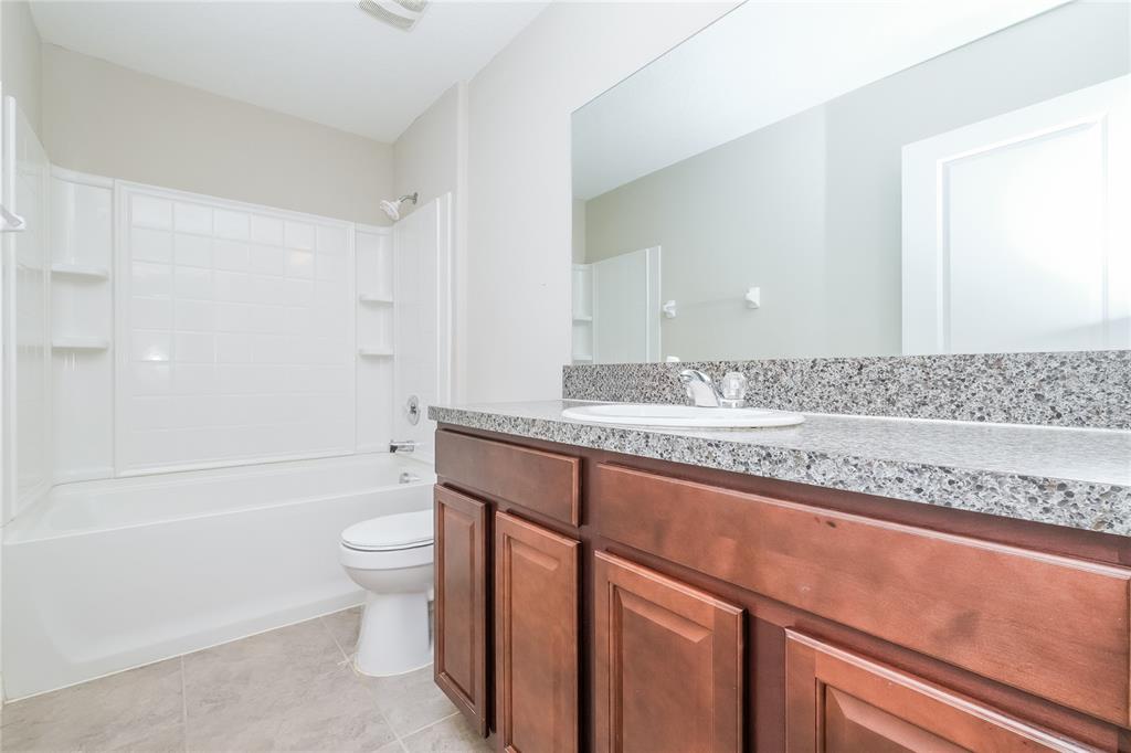 36125 Stable Wilk Avenue Zephyrhills, FL 33541 - Photo 14 of 17 a bathroom with a granite countertop bathtub sink vanity mirror and toilet